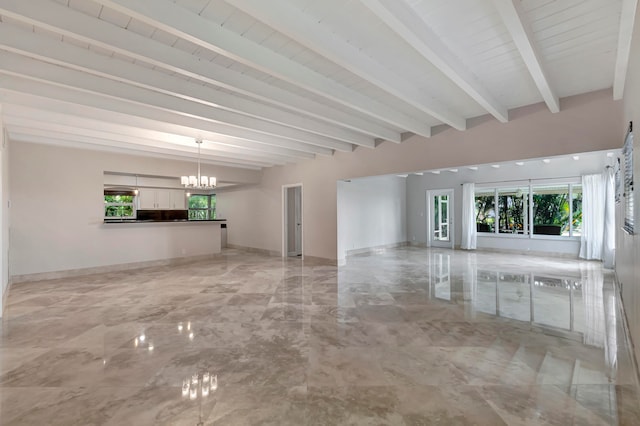 unfurnished living room with beamed ceiling and a chandelier