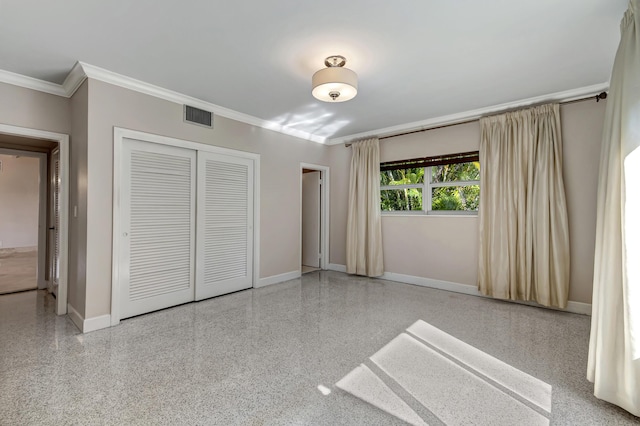 unfurnished bedroom with crown molding and a closet