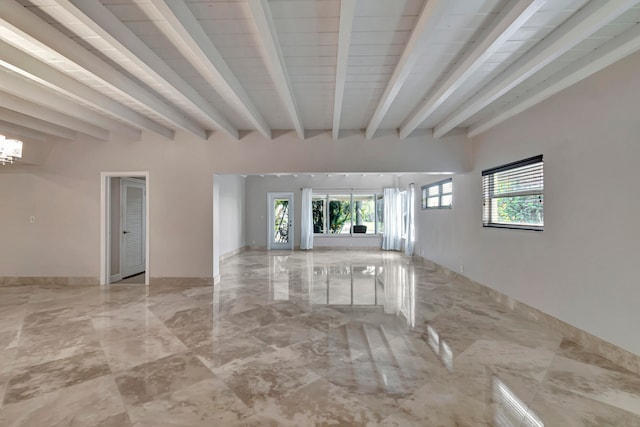 unfurnished living room with beam ceiling, a healthy amount of sunlight, and an inviting chandelier