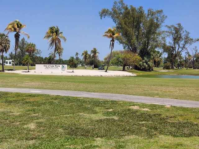 view of community with a water view and a yard