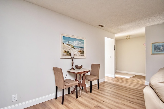 sitting room with a textured ceiling and light hardwood / wood-style floors