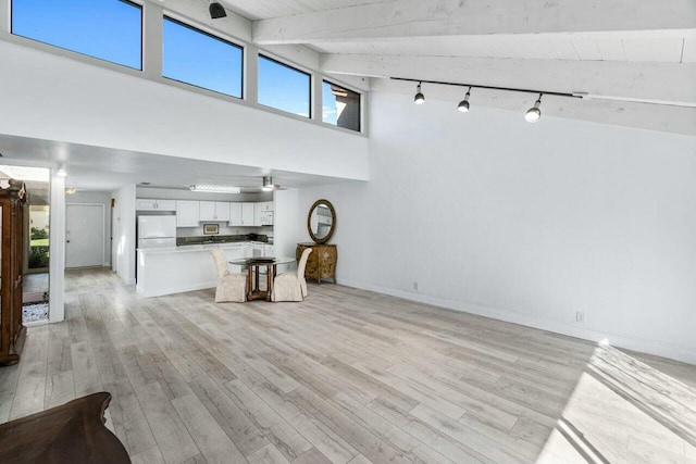 living room featuring beamed ceiling, high vaulted ceiling, and light hardwood / wood-style flooring