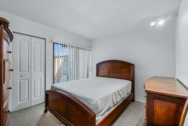 carpeted bedroom featuring a textured ceiling and a closet