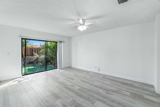 empty room with ceiling fan, a textured ceiling, and light wood-type flooring