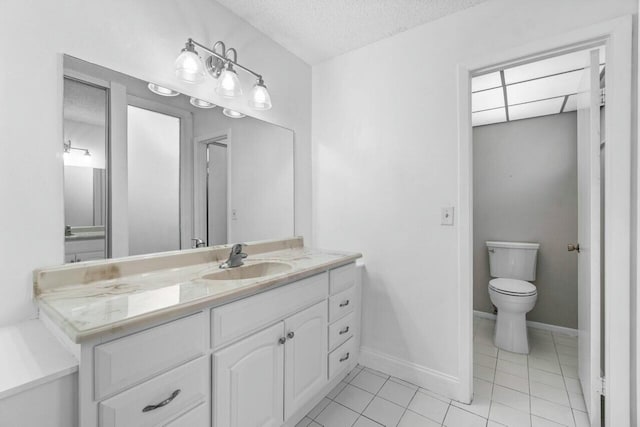 bathroom with tile patterned floors, vanity, toilet, and a textured ceiling