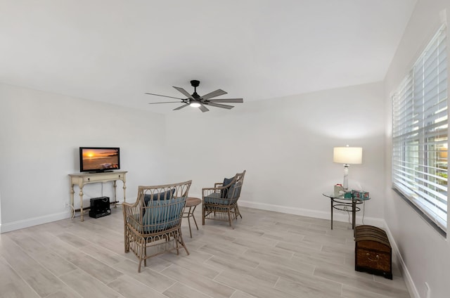 sitting room featuring baseboards, a ceiling fan, and wood finish floors