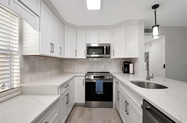 kitchen with stainless steel appliances, visible vents, backsplash, white cabinetry, and a sink