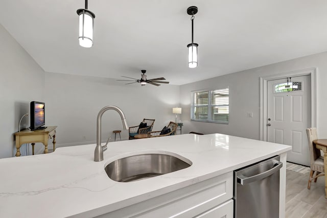 kitchen with pendant lighting, white cabinets, dishwasher, and a sink