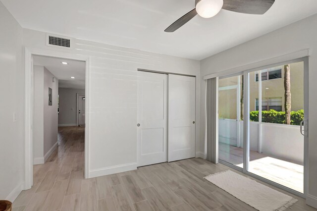 unfurnished bedroom featuring access to exterior, a closet, visible vents, light wood-style floors, and baseboards