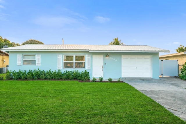 ranch-style home with cooling unit, a garage, and a front lawn