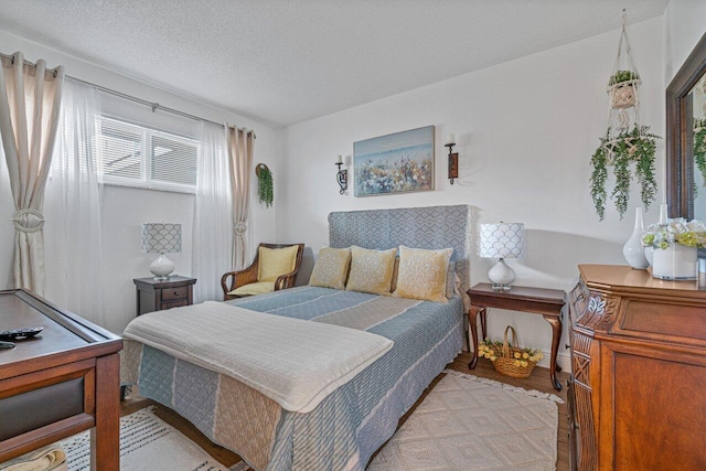 bedroom with light wood-type flooring and a textured ceiling