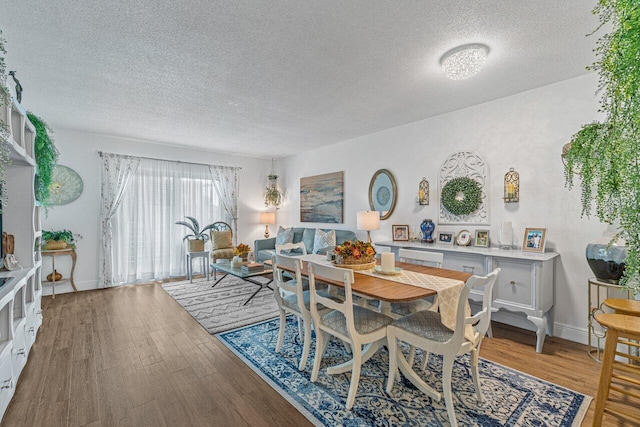 dining area featuring a textured ceiling and hardwood / wood-style flooring