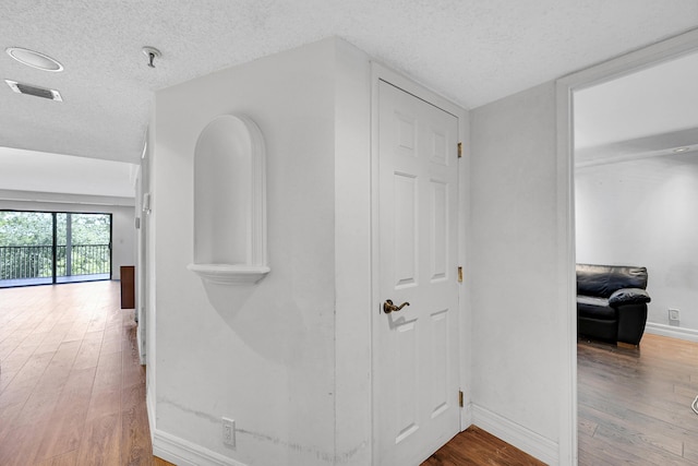 hallway featuring wood-type flooring and a textured ceiling