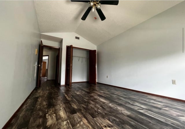 unfurnished bedroom featuring a closet, hardwood / wood-style flooring, vaulted ceiling, a textured ceiling, and ceiling fan