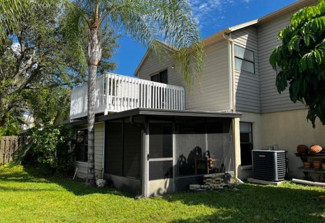 back of house with a yard, a sunroom, a balcony, and cooling unit