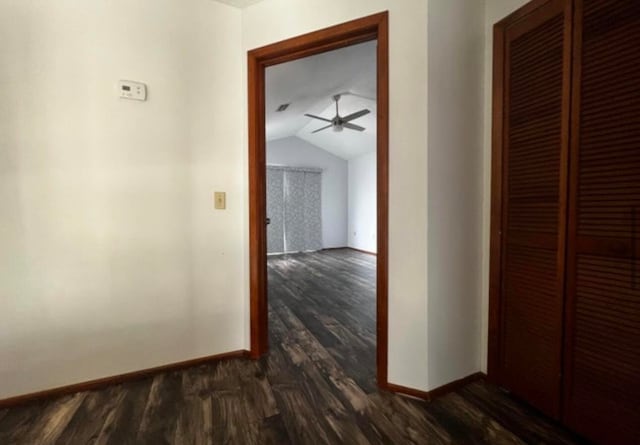 hall featuring dark hardwood / wood-style flooring and vaulted ceiling