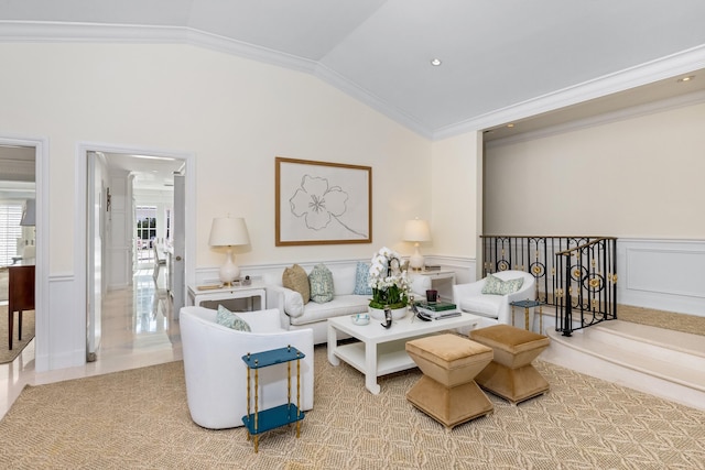 living area with a wainscoted wall, crown molding, and vaulted ceiling