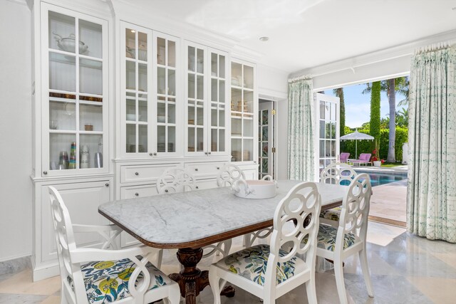 tiled dining area with sink and ornamental molding