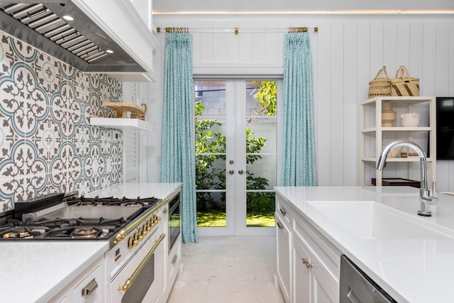 kitchen with a sink, light countertops, custom exhaust hood, white cabinetry, and open shelves