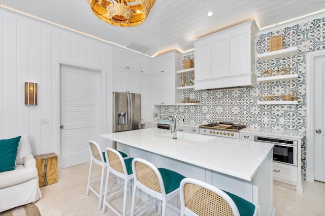 kitchen with open shelves, a sink, tasteful backsplash, stainless steel appliances, and light countertops