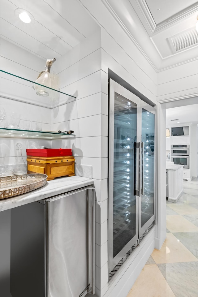 interior space featuring visible vents, beverage cooler, and ornamental molding