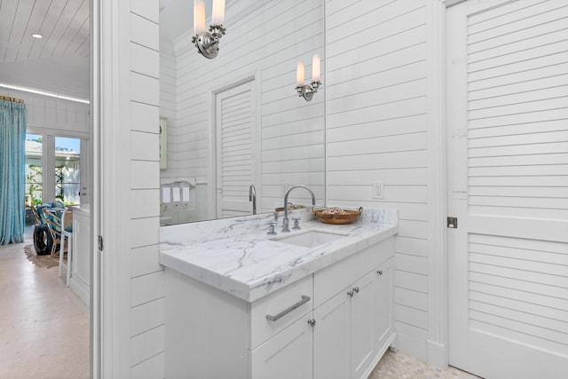 bathroom featuring wooden walls and vanity