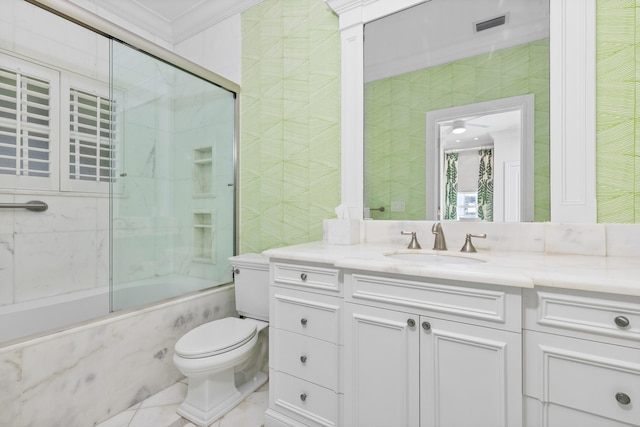 bathroom with visible vents, toilet, combined bath / shower with glass door, tile walls, and vanity