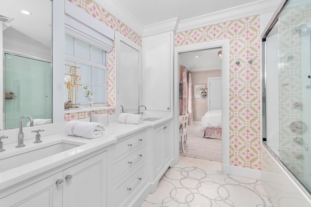 bathroom with a sink, connected bathroom, ornamental molding, and wallpapered walls