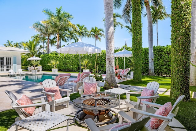 view of patio featuring french doors, an outdoor pool, and an outdoor fire pit