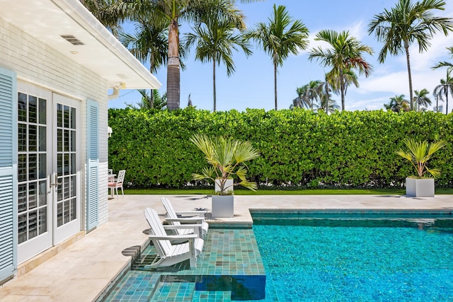 view of pool with a patio area, french doors, and a fenced in pool