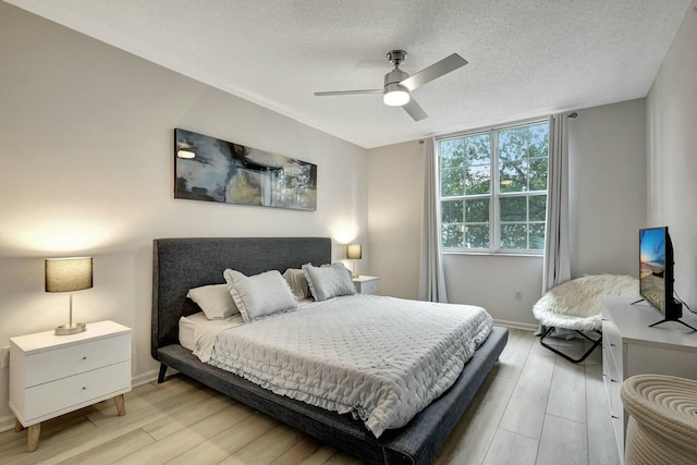 bedroom featuring ceiling fan, a textured ceiling, and light hardwood / wood-style flooring