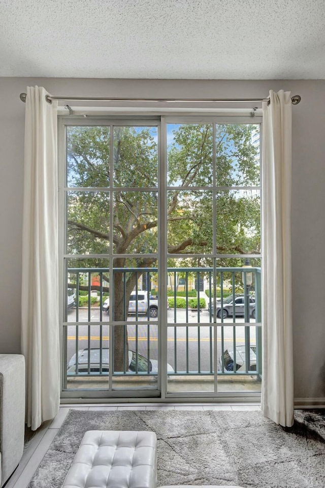 doorway to outside with a textured ceiling