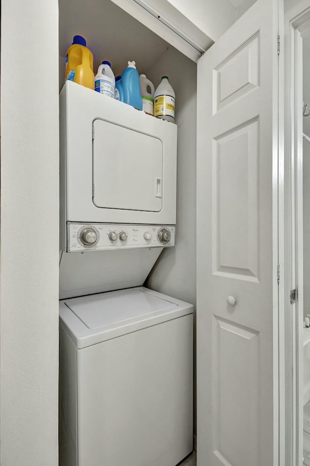 clothes washing area featuring stacked washer and dryer