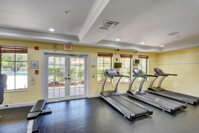 workout area featuring a raised ceiling, crown molding, plenty of natural light, and french doors