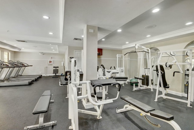 gym with crown molding and a tray ceiling