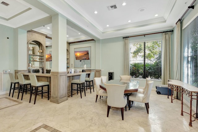 dining area with ornamental molding and a tray ceiling