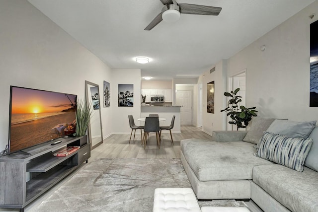 living room featuring ceiling fan and light wood-type flooring