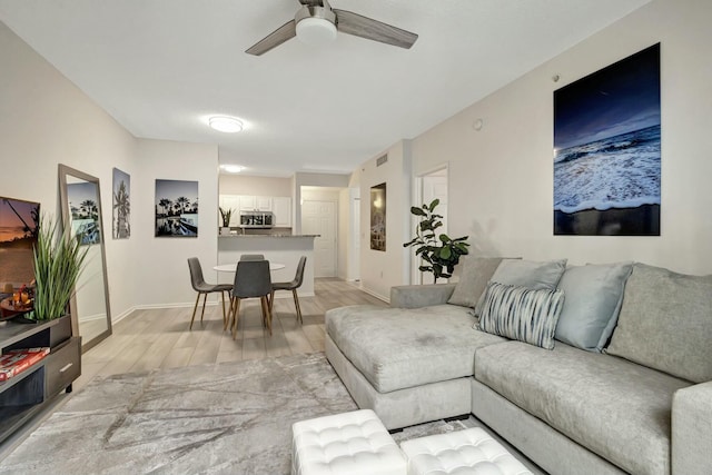 living room with ceiling fan and light hardwood / wood-style floors