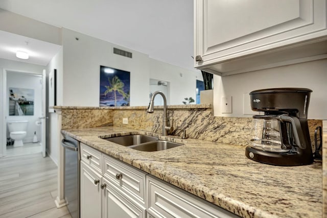 630 S Sapodilla Ave Unit 223, West Palm Beach, FL 33401 - kitchen with a sink, backsplash, light stone counters, and white cabinets