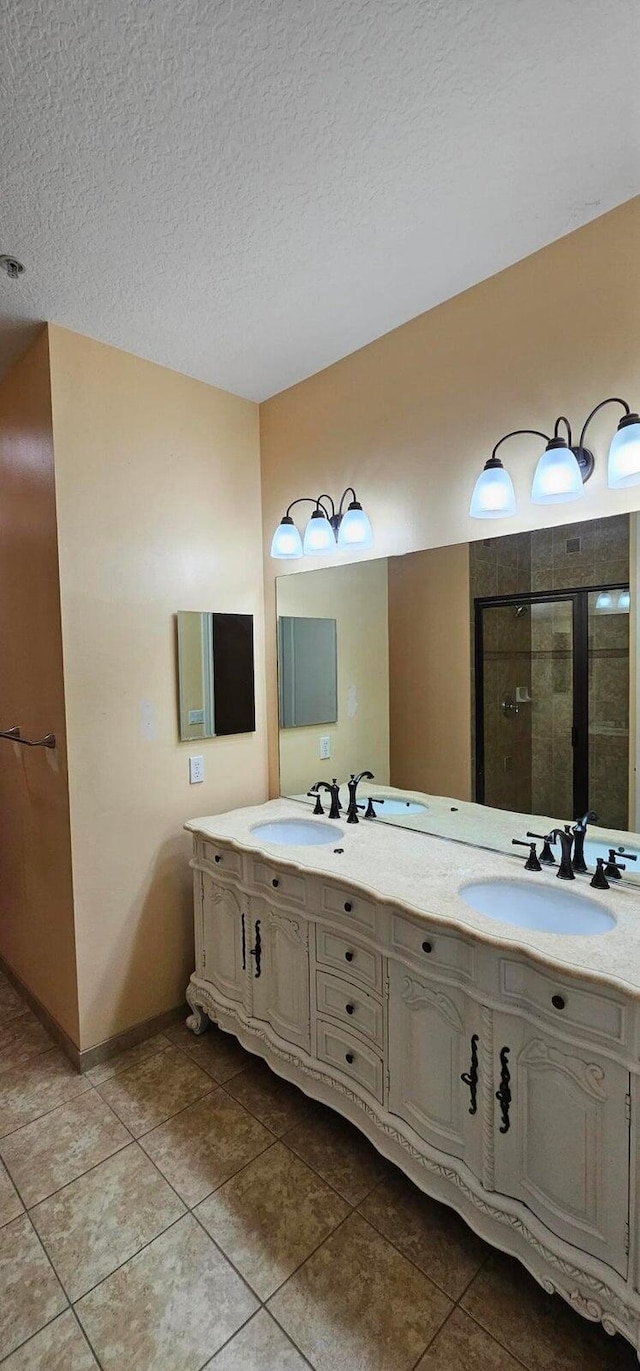 bathroom featuring walk in shower, vanity, tile patterned flooring, and a textured ceiling