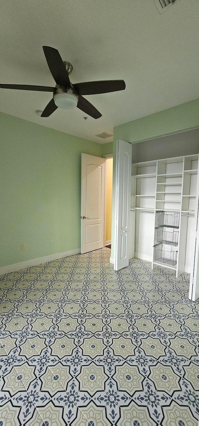 unfurnished bedroom with ceiling fan and a closet