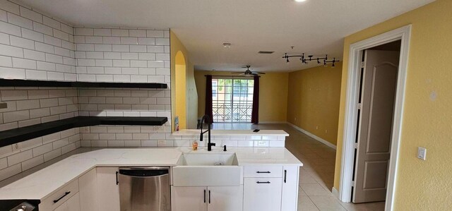 kitchen with ceiling fan, backsplash, dishwasher, sink, and white cabinets