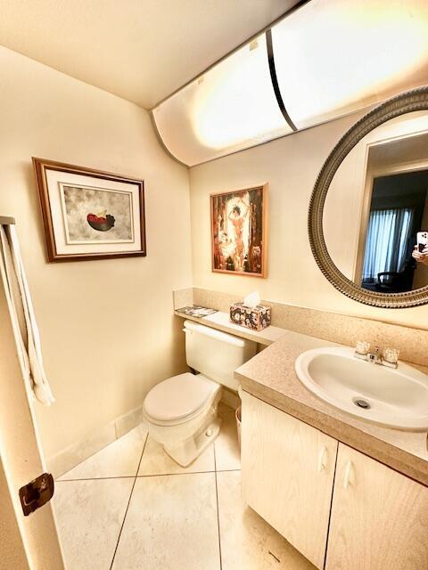 bathroom featuring vanity, tile patterned floors, and toilet