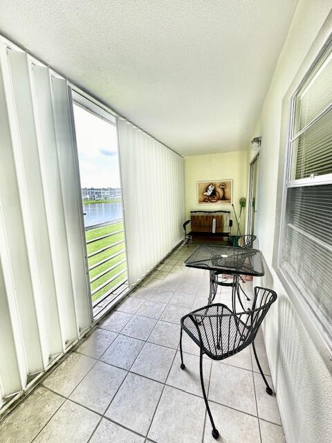 sunroom / solarium featuring a water view