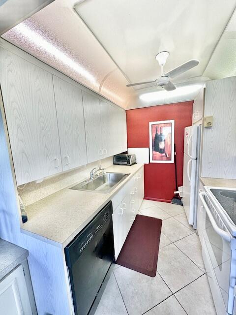 kitchen featuring ceiling fan, sink, light tile patterned floors, and white appliances