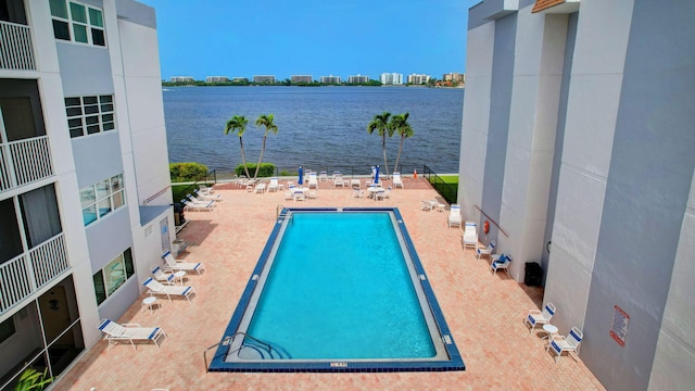 view of pool with a patio area and a water view