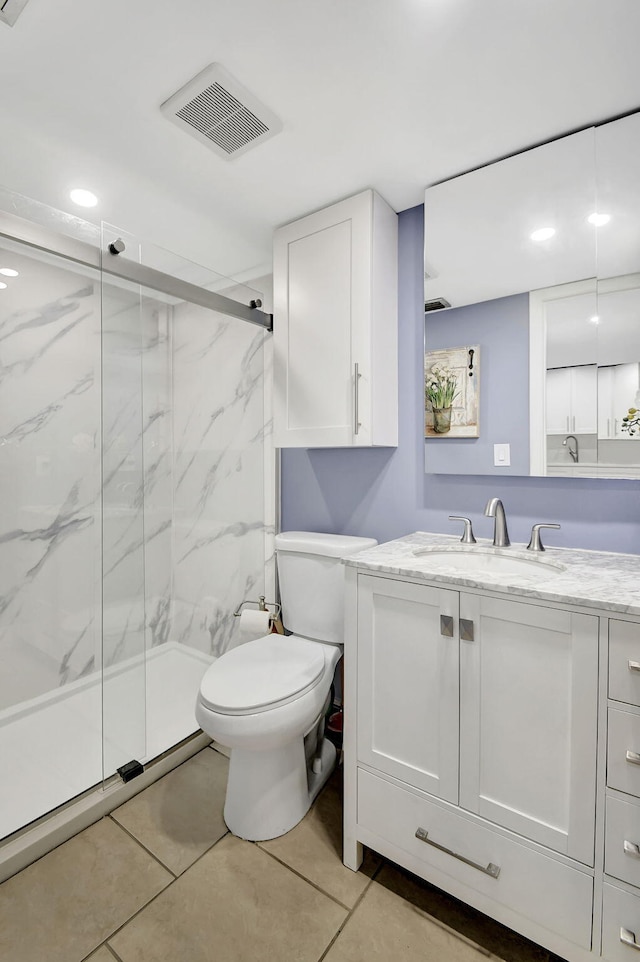 bathroom with tile patterned flooring, vanity, toilet, and a shower with shower door