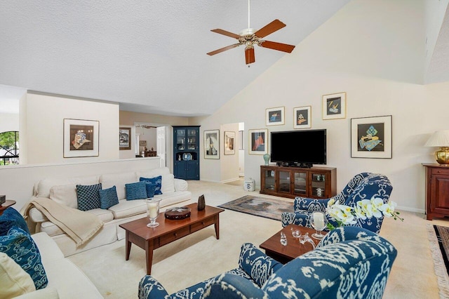 carpeted living room with a textured ceiling, ceiling fan, and high vaulted ceiling