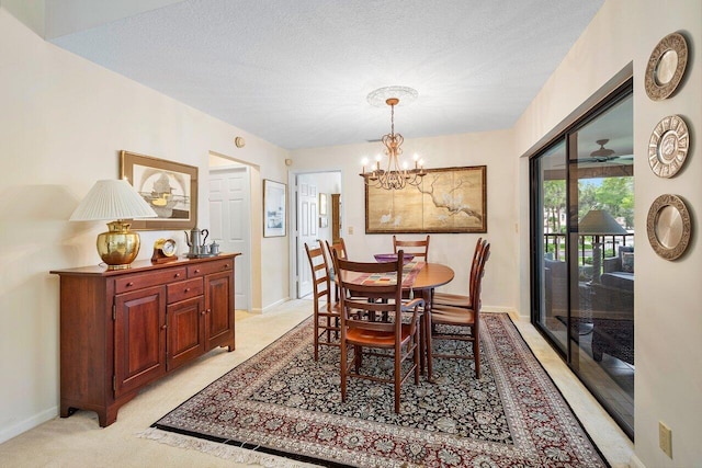 dining room featuring a notable chandelier, light carpet, and a textured ceiling