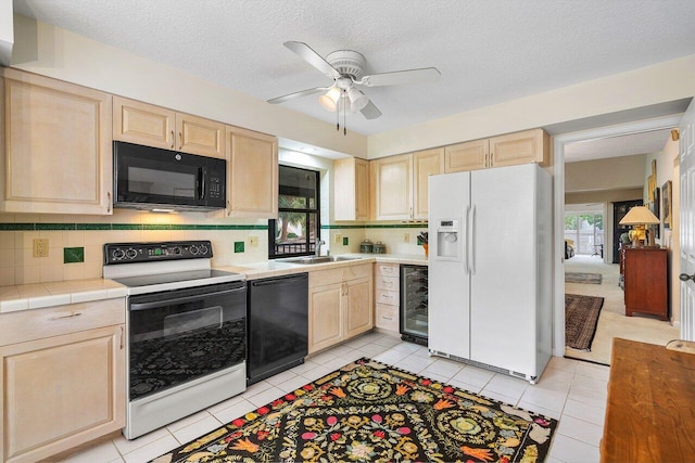 kitchen featuring black appliances, tasteful backsplash, beverage cooler, and sink